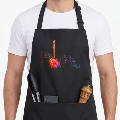 Tablier de cuisine noir avec illustration d'un banjo orange et de partitions musicales colorées s'écoulant en courbe.
