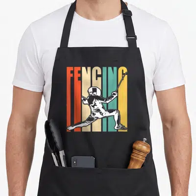 Tablier de cuisine noir avec illustration rétro d'un escrimeur et le mot FENCING en lettres colorées verticales.
