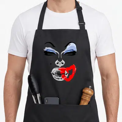 Tablier de cuisine noir avec portrait graphique de Drag Queen aux yeux bleus et lèvres rouges égrenées.