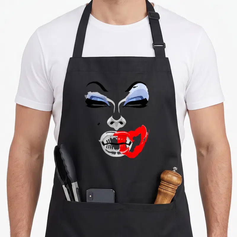 Tablier de cuisine noir avec portrait graphique de Drag Queen aux yeux bleus et lèvres rouges égrenées.