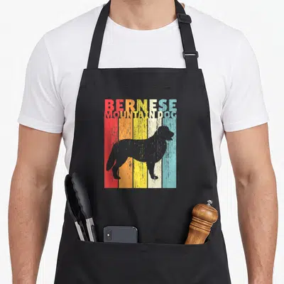 Tablier de cuisine noir avec silhouette de bouvier bernois sur bandes colorées et texte BERNES MOUNTAIN DOG.