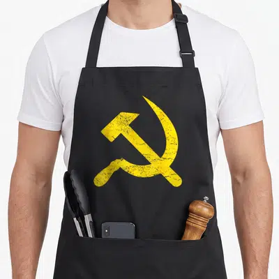 Tablier de cuisine noir avec emblème marteau faucille CCCP jaune délavé au centre.