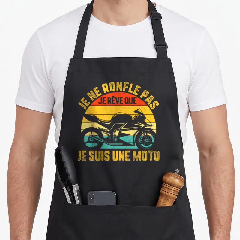 Tablier de cuisine noir avec illustration vintage d'un scooter et texte humoristique sur fond de soleil coloré.