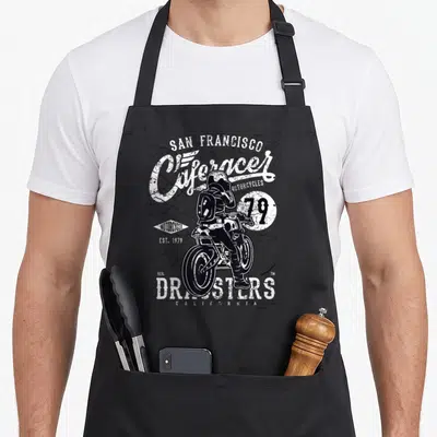 Tablier de cuisine noir avec illustration vintage d'un pilote de moto et les mots Cafe Racer Dragsters 79 San Francisco.