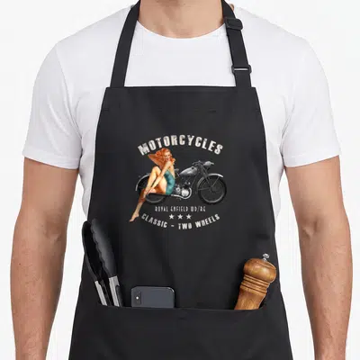 Tablier de cuisine noir avec illustration pin up blonde sur moto vintage Royal Enfield Wdre en teintes gris et turquoise.