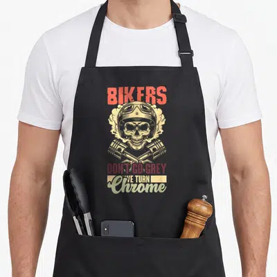Tablier de cuisine noir avec illustration crâne casque biker et texte Bikers Don't Go Grey We Turn Chrome.