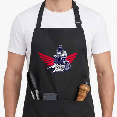 Tablier de cuisine noir avec illustration d'un pilote Africa Twin et ailes rayées rouges stylisées.