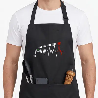 Tablier de cuisine noir avec tracé d'électrocardiogramme transformé en compteur de vitesses numérotés de un à six, dont le six est rouge.
