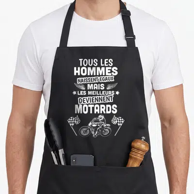 Tablier de cuisine noir avec inscription blanche sur le thème des motards et un pilote en course entre deux drapeaux à damier.