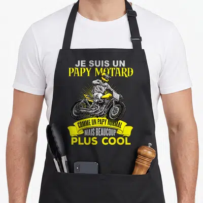 Tablier de cuisine noir avec une illustration d'un cyclomoteur jaune et le texte Je suis un papy motard plus cool.
