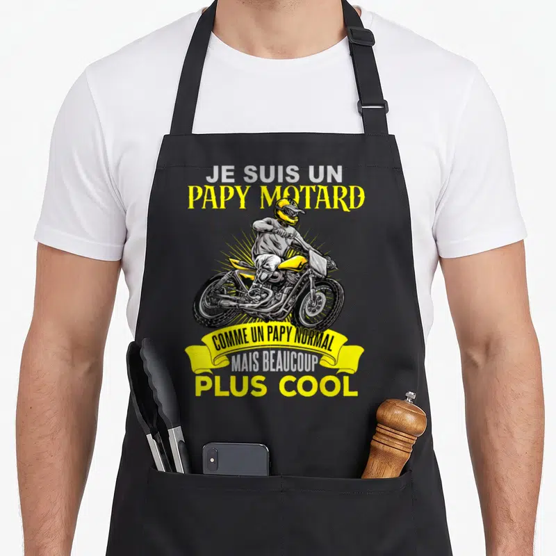 Tablier de cuisine noir avec une illustration d'un cyclomoteur jaune et le texte Je suis un papy motard plus cool.