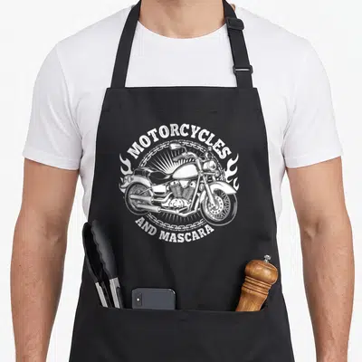 Tablier de cuisine noir avec illustration blanche d'un cruiser encadré par des chaînes et le texte Motocycles and Mascara.