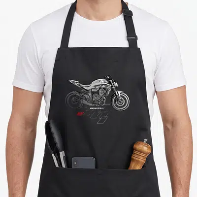Tablier de cuisine noir avec illustration stylisée d'une moto de course blanche, effets de vitesse et logo Ridezza en bas.