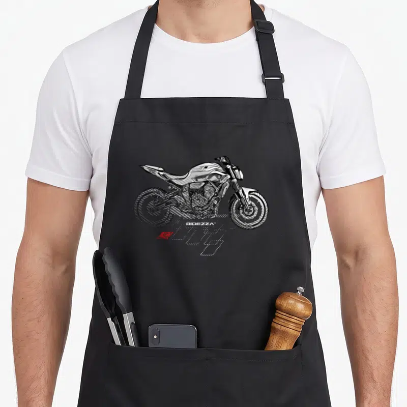 Tablier de cuisine noir avec illustration stylisée d'une moto de course blanche, effets de vitesse et logo Ridezza en bas.