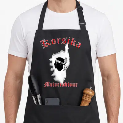 Tablier de cuisine noir avec le mot Corsika en rouge et une silhouette corse blanche au centre.