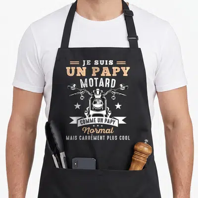 Tablier de cuisine noir avec illustration avant de moto et texte humoristique sur un papy motard cool.