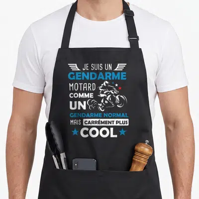 Tablier de cuisine noir avec inscription gendarme motard comme un gendarme normal mais carrément plus cool et silhouette de moto stylisée.