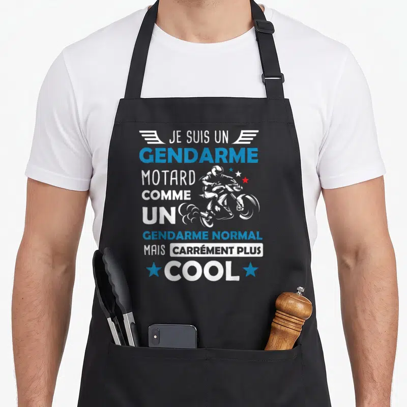 Tablier de cuisine noir avec inscription gendarme motard comme un gendarme normal mais carrément plus cool et silhouette de moto stylisée.