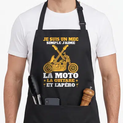 Tablier de cuisine noir avec illustration orange d'une moto et deux guitares croisées sous un texte humoristique.