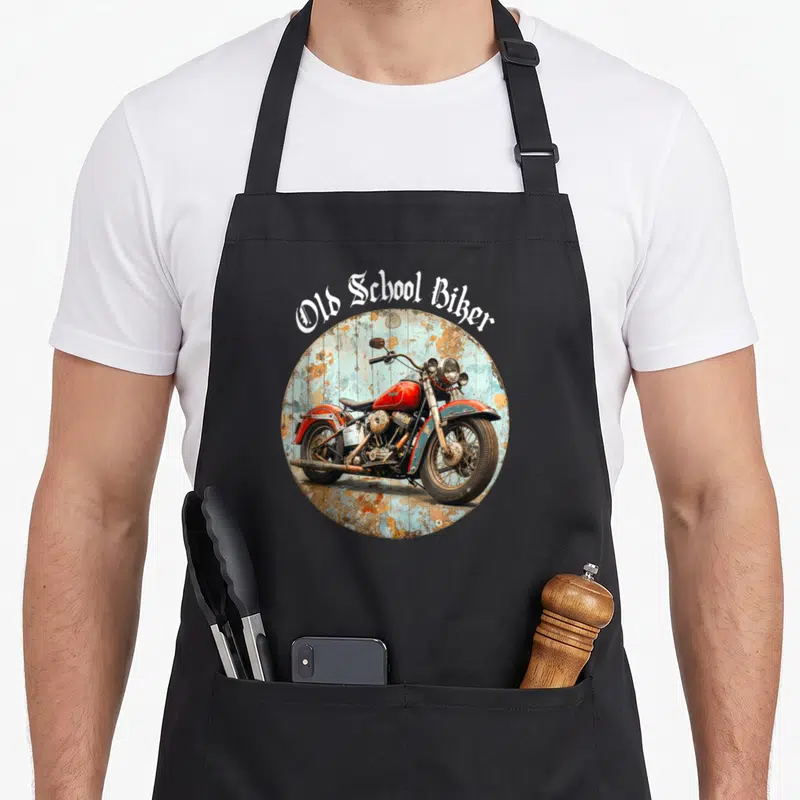 Tablier de cuisine noir avec illustration circulaire d'une moto vintage rouge et texte Old School Biker en typographie gothique blanche.