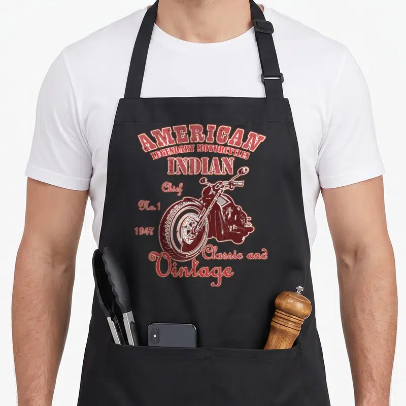 Tablier de cuisine noir avec illustration vintage d'une moto American Indian et typographie rouge indiquant 1947 Classic and Vintage.