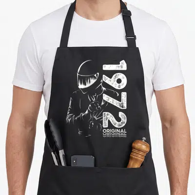 Tablier de cuisine noir avec illustration blanche d'un motard en train de serrer ses gants et le chiffre 1972.
