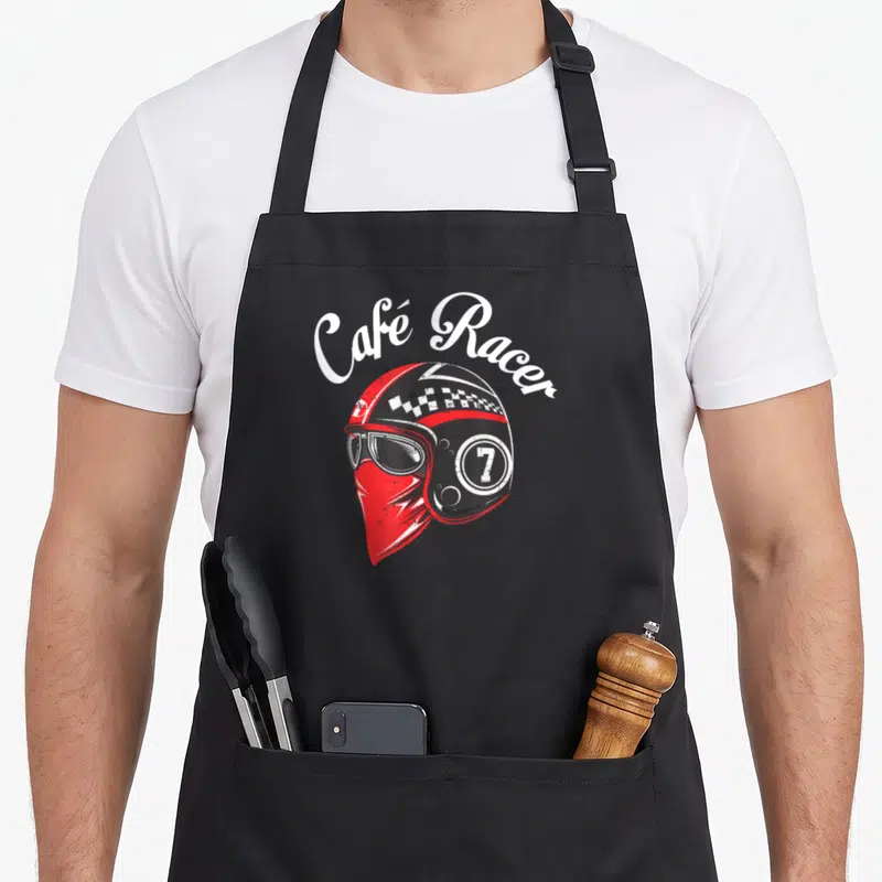 Tablier de cuisine noir avec illustration d'un casque Café Racer rouge, lunettes et bandana sous le menton.