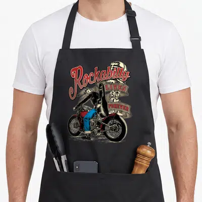 Tablier de cuisine noir avec illustration rockabilly d'un musicien sur custom motorcycle portant une guitare et un casque vintage.