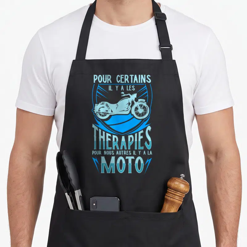 Tablier de cuisine noir avec une illustration bleue de moto et le texte sur les thérapies et la moto.