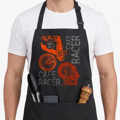 Tablier de cuisine noir avec illustration technique d'une moto Cafe Racer en orange et texte gris.