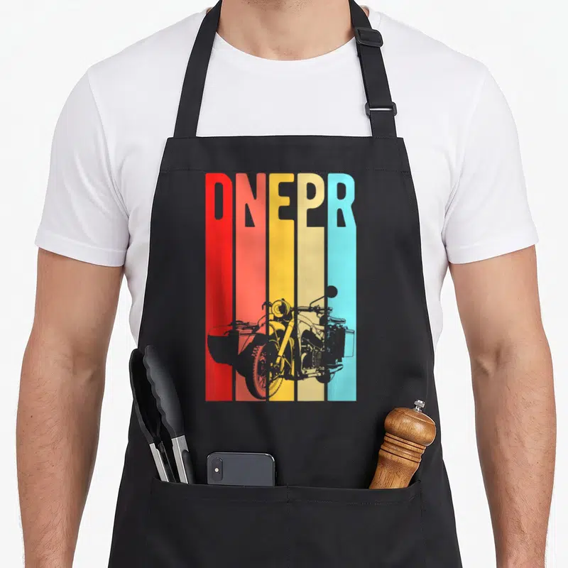 Tablier de cuisine noir avec l'inscription DNEPR en bandes colorées et silhouette de moto avec side-car.