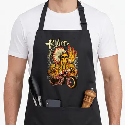 Tablier de cuisine noir avec illustration d'un crâne en coiffe indienne sur une moto custom.