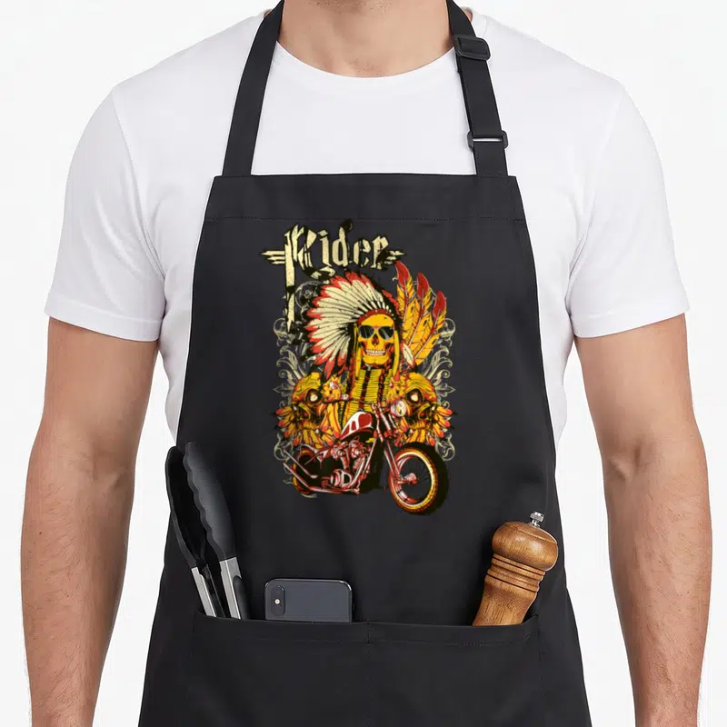Tablier de cuisine noir avec illustration d'un crâne en coiffe indienne sur une moto custom.