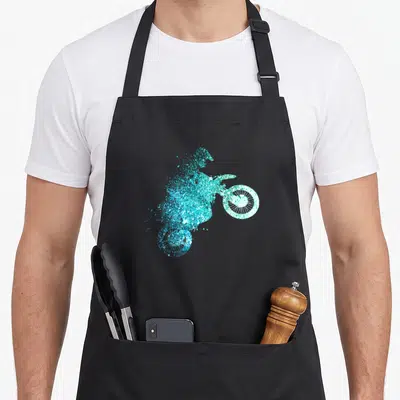 Tablier de cuisine noir avec une silhouette de motocross formée de particules turquoise éclatantes.
