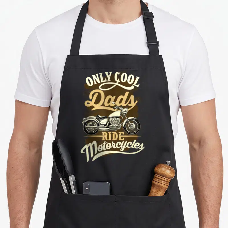 Tablier de cuisine noir avec inscription Only Cool Dads Ride Motorcycles et dessin de moto vintage beige et marron.