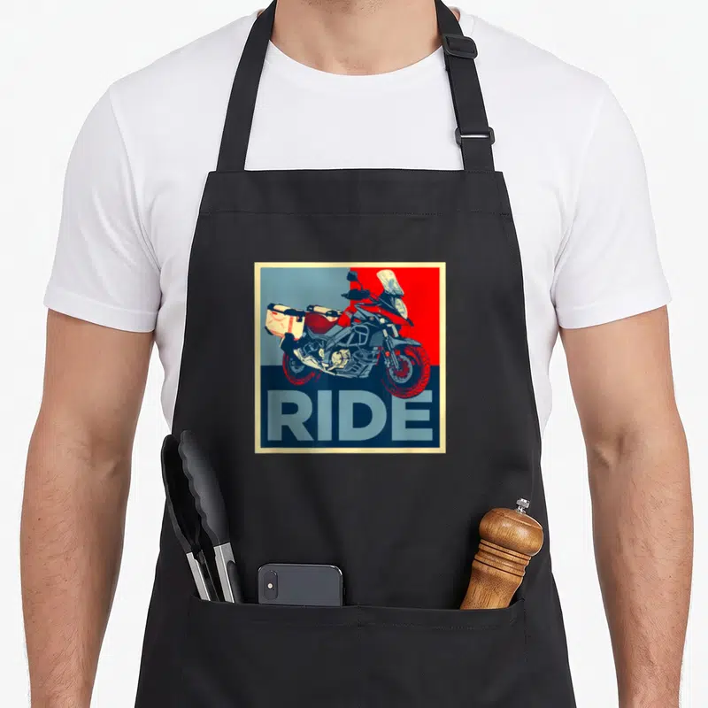 Tablier de cuisine noir avec illustration de moto adventure RIDE sur fond rouge et bleu géométrique.