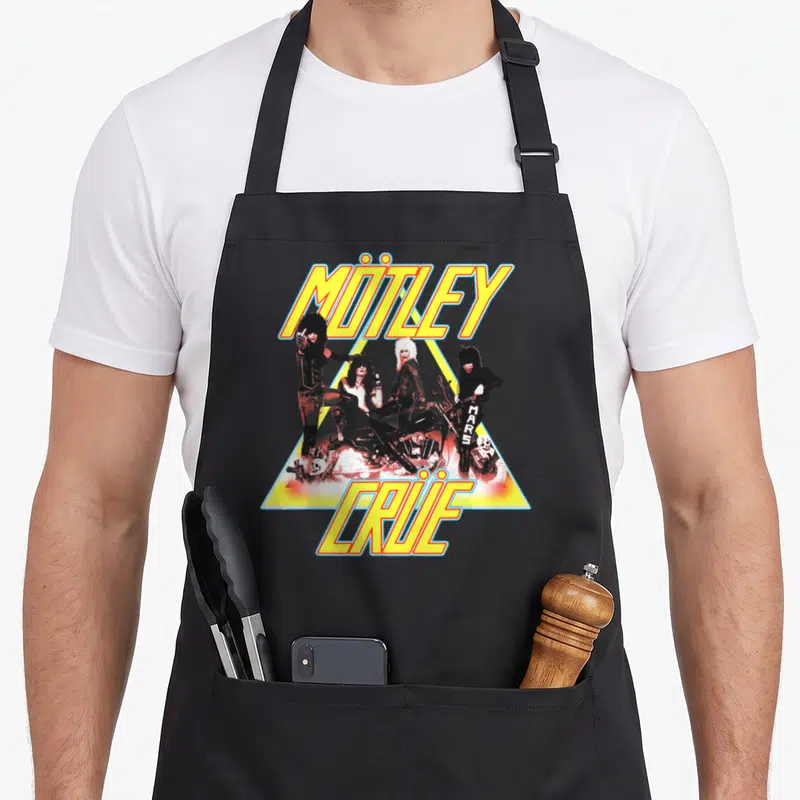 Tablier de cuisine noir avec illustration colorée du groupe Mötley Crüe sur un triangle jaune et une moto.