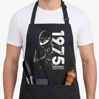 Tablier de cuisine noir avec illustration motard casque et inscription 1975 original en blanc.
