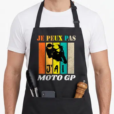 Tablier de cuisine noir avec une illustration vintage de pilote de Moto GP sur bandes colorées et texte humoristique.