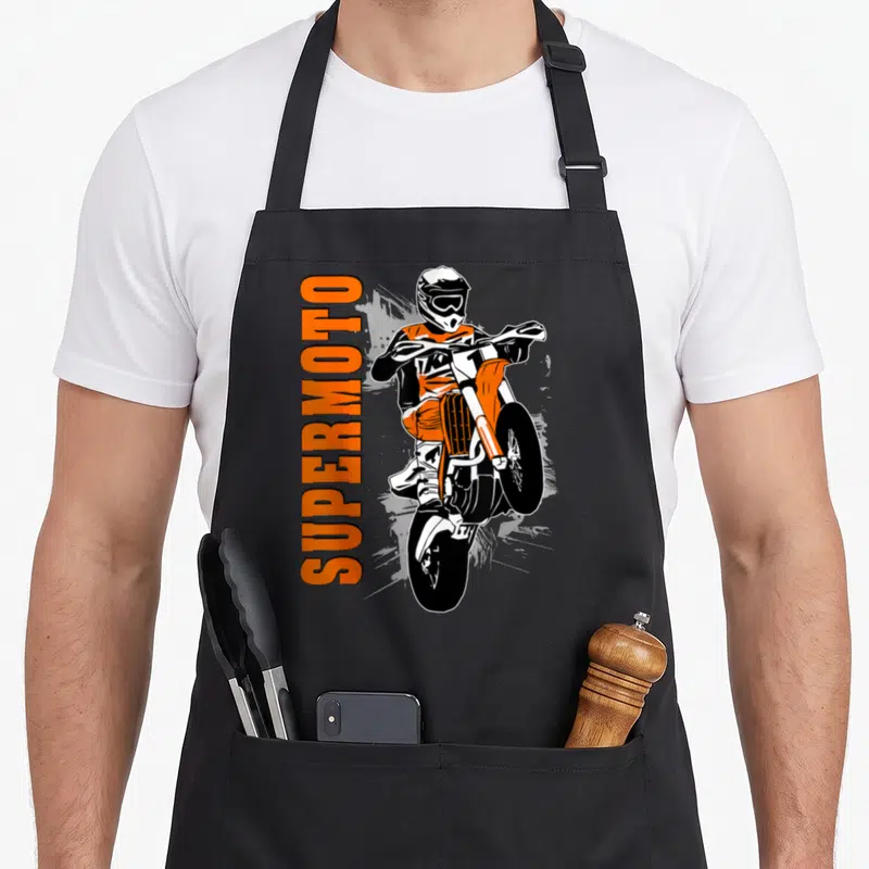 Tablier de cuisine noir avec illustration orange d'un supermotard en wheelie et texte SUPERMOTO vertical.