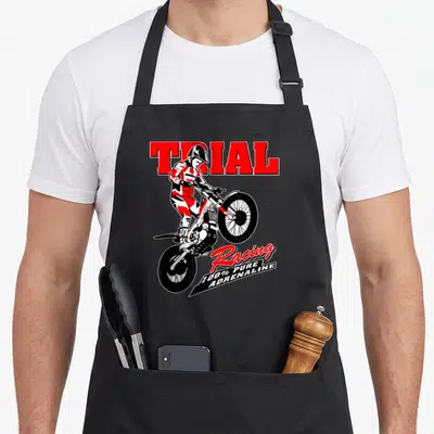 Tablier de cuisine noir avec illustration d'un pilote de trial sur moto rouge et blanche et texte Trial Racing 100% Pure Adrenaline.