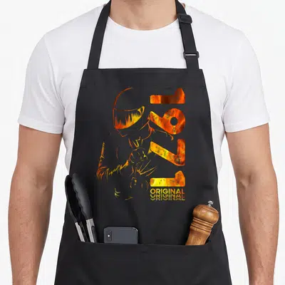 Tablier de cuisine noir avec illustration orange d'un motard casqué et l'année 1971 en lettres métalliques.
