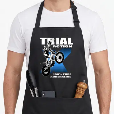 Tablier de cuisine noir avec illustration pilote trial texte Trial Action 100% Pure Adrenaline fond bleu.