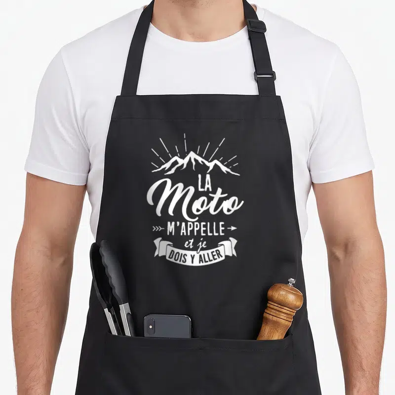 Tablier de cuisine noir avec inscription blanche la Moto m'appelle et je dois y aller au-dessus d'un motif de montagnes.