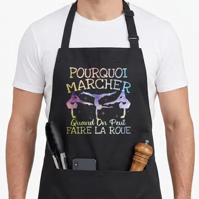 Tablier de cuisine noir avec silhouette de trois gymnastes en roue et texte coloré style cosmos.