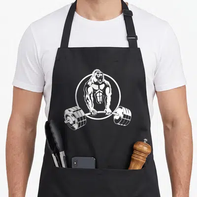 Tablier de cuisine noir avec illustration blanche d'un gorille musclé tenant une barre de poids.