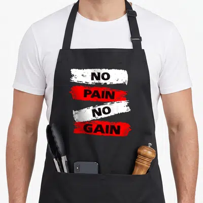 Tablier de cuisine noir avec les mots No Pain No Gain imprimés sur des bandes rouges et blanches texturées.
