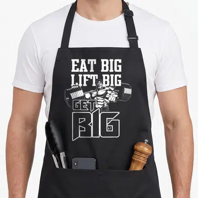 Tablier de cuisine noir avec un culturiste en blanc et le texte Eat Big Lift Big Get Big imprimé au centre.