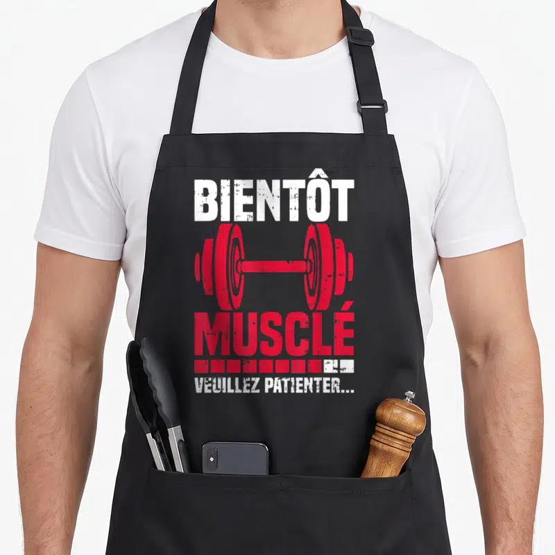 Tablier de cuisine noir avec illustration de barre rouge et texte Bientôt Musclé Veuillez Patienter en blanc.