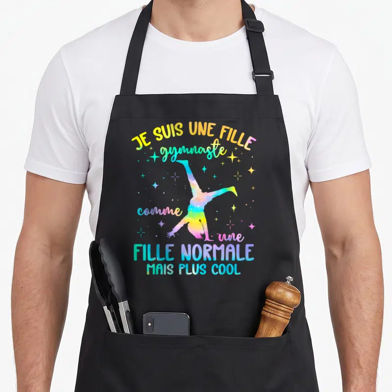 Tablier de cuisine noir avec une gymnaste aquarelle et le texte Je suis une fille gymnaste comme une fille normale mais plus cool.